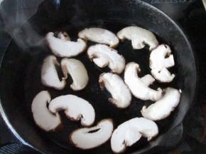 饧牛排的时间，把香菇片放入锅中，利用锅中底油煎
