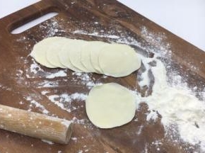 把小圆剂子压平，擀成饺子皮，擀饺子皮要中间厚四周边薄。