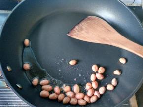 花生米冷油下锅，小火慢炒，炒香后盛出放凉。