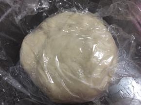 然后用手或面包机揉面，揉成光滑的面团，然后用保鲜膜盖住静置1小时