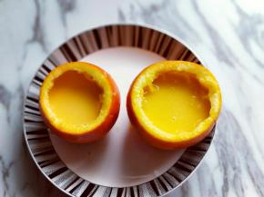 过细筛的橙子蛋液倒入橙子壳中。