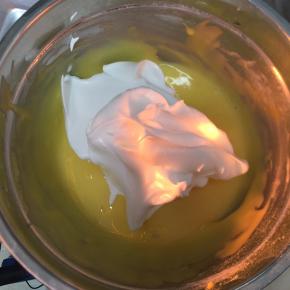 蛋黄糊中加入三分之一蛋白糊，用刮刀翻拌均匀（不要画圈搅拌）