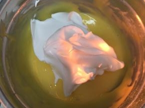 蛋黄糊中加入三分之一蛋白糊，用刮刀翻拌均匀（不要画圈搅拌）