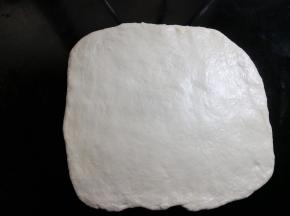 把松弛好的面团，擀开成正方形，跟烤盘大致等大，边缘上气泡拍掉。