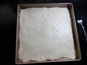 放入28×28的烤盘中。把边缘部分整理好， 边缘如果有多余的部分，可以用刀切掉。