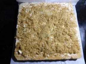 一定要趁热来卷哦。面包倒扣的油纸上，也能更好的把面包卷起，在靠近自己身体的一侧，相隔1厘米左右，浅浅横切二刀，注意不要把面包切断。在离自己较远的那一端，以45度角斜切一刀，这样卷起切片后会比较美观，不切也可以的。在面包的反面涂上一层沙拉酱，撒上肉松。