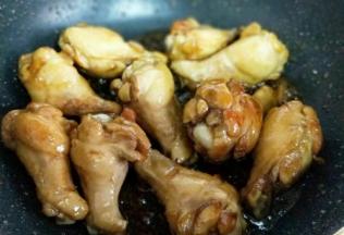 加入腌制好的鸡翅根，翻炒使糖色均匀挂满每个鸡翅根。