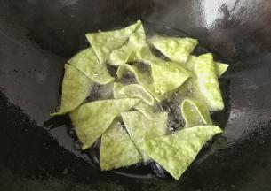 把三角面片一片一片的放入锅中小火炸，及时用筷长翻拨几次