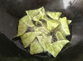 把三角面片一片一片的放入锅中小火炸，及时用筷长翻拨几次