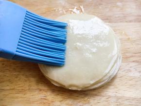 取一张饺子皮，在表面刷上薄薄一层的油。