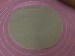 用擀面杖擀成中间厚边缘薄的面皮