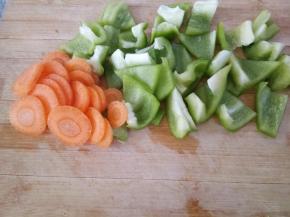 上面炖煮的过程来处理蔬菜。青椒切块，胡萝卜切厚片