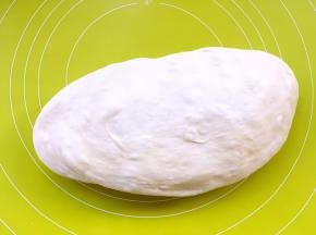 将发酵好的面团取出，用手掌按压面团表面排气，注意力度不要过大