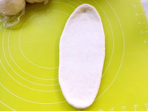 取一份松弛好的面团，用擀面杖擀成长条