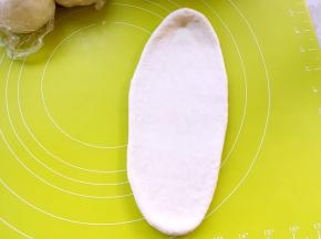 取一份松弛好的面团，用擀面杖擀成长条