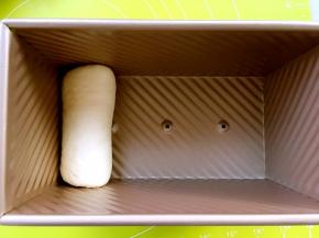 将卷好的面团放入450克吐司模具内，之后用同样的方法卷起另外两份面团