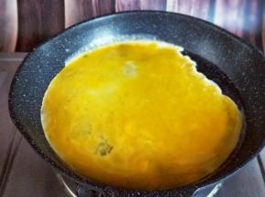 起油锅，又热时倒入蛋液，小火煎蛋饼，待蛋液凝固后再将鸡蛋饼切碎。