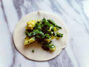 取一张饺子皮，放入韭菜鸡蛋馅。