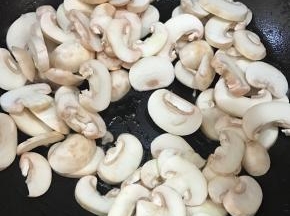 锅中可再加入少许油，将蘑菇倒入。