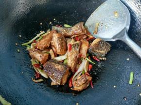 炸好的鱼块倒入锅中。