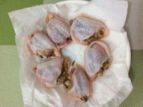 将晾凉的米饭都塞入鸡翅中，然后放在厨房纸巾上吸一下水份