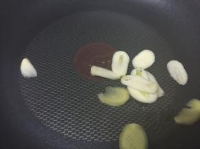 中火热锅，倒入1勺油，放入蒜头和姜片，爆香