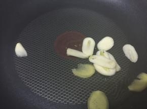 中火热锅，倒入1勺油，放入蒜头和姜片，爆香
