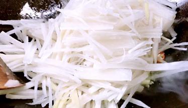 放入白萝卜丝，炒断生