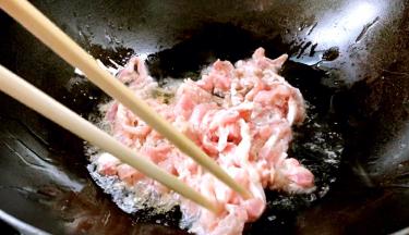锅置火上，放入食用油，五成热时放入腌制好的猪瘦肉，炒断生
