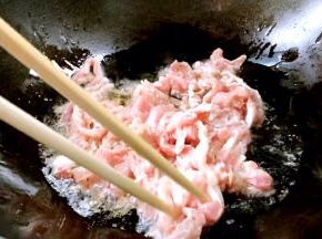 锅置火上，放入食用油，五成热时放入腌制好的猪瘦肉，炒断生