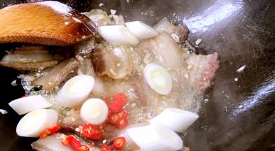 加入小米椒、大葱段炒香