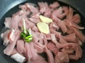 切好的里脊肉放入锅中，加入清水，没过里脊肉为佳，加入切好的姜片，葱。