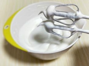 将电动打蛋器调低速打发一会儿，感觉有些阻力时，就可以停止打发，以免消泡，提起打蛋器有微微的弯勾就可以，如图