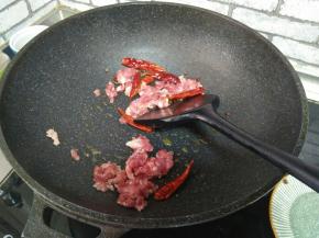 加入干红椒，麻椒。再加入肉末炒至变白。