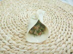 拿一张饺子皮，放上少许肉馅，饺子皮对捏