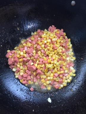 放入切好的火腿肠丁翻炒均匀。