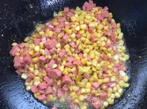 放入切好的火腿肠丁翻炒均匀。