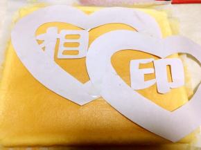 将裁好的图案铺在蛋糕上，用小刀一点点裁出了，不够的半颗心用边角拼接一下