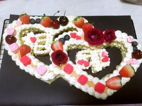 玫瑰花根部用保鲜膜包裹好，装饰在蛋糕上，草莓留蒂，对切开，跟车厘子、蓝莓分别装饰在蛋糕上，心形巧克力跟LOVE520巧克力也装饰上