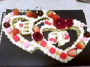 玫瑰花根部用保鲜膜包裹好，装饰在蛋糕上，草莓留蒂，对切开，跟车厘子、蓝莓分别装饰在蛋糕上，心形巧克力跟LOVE520巧克力也装饰上