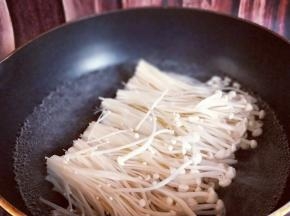 冲洗干净后将金针菇焯水，尽量不要把金针菇弄乱，保持整齐。(也可以不焯水，根据个人习惯)