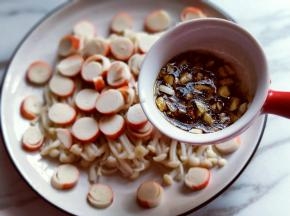 再将拌均匀的调味料淋再蟹肉棒金针菇上面即可。