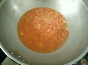 倒入番茄，煸炒番茄至变软。加入适量热水烧开。