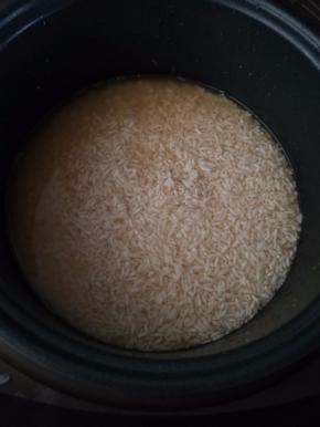 浸泡后的糯米加入电饭煲，煮糯米的那个水就是泡香菇的水，水量只要超过米平面5毫米就好。