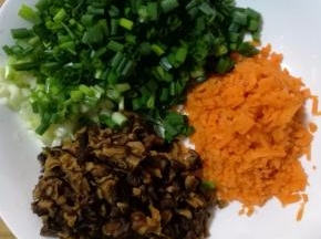 煮饭的时候我们可以处理别的食材，将香菇和胡萝卜切小丁，小葱洗净切葱花备用。