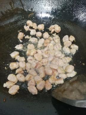 差不多糯米饭煮好了，在炒锅里倒入适量的食用油，油热后放入香肠炒熟至变色。
