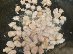 差不多糯米饭煮好了，在炒锅里倒入适量的食用油，油热后放入香肠炒熟至变色。