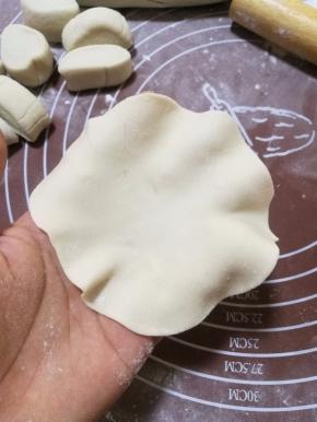 将剂子擀成比饺子皮大点的中间厚点四周薄的圆片。