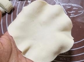 将剂子擀成比饺子皮大点的中间厚点四周薄的圆片。