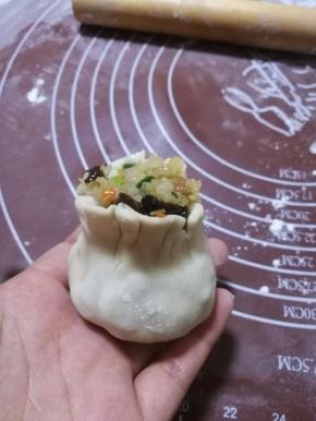 在利用虎口，将烧麦收口，掐出腰身，一个烧麦就做好了。